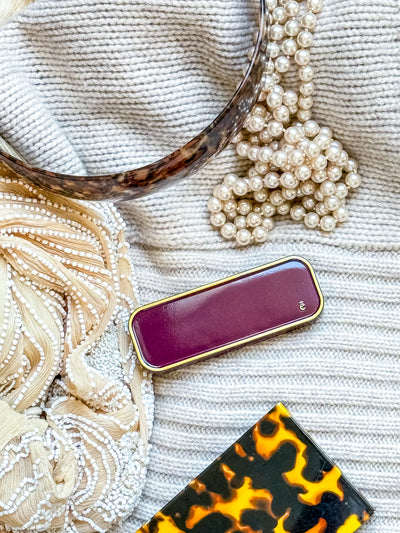 Burgundy ema fragrance solid perfume compact on textured fabric background
