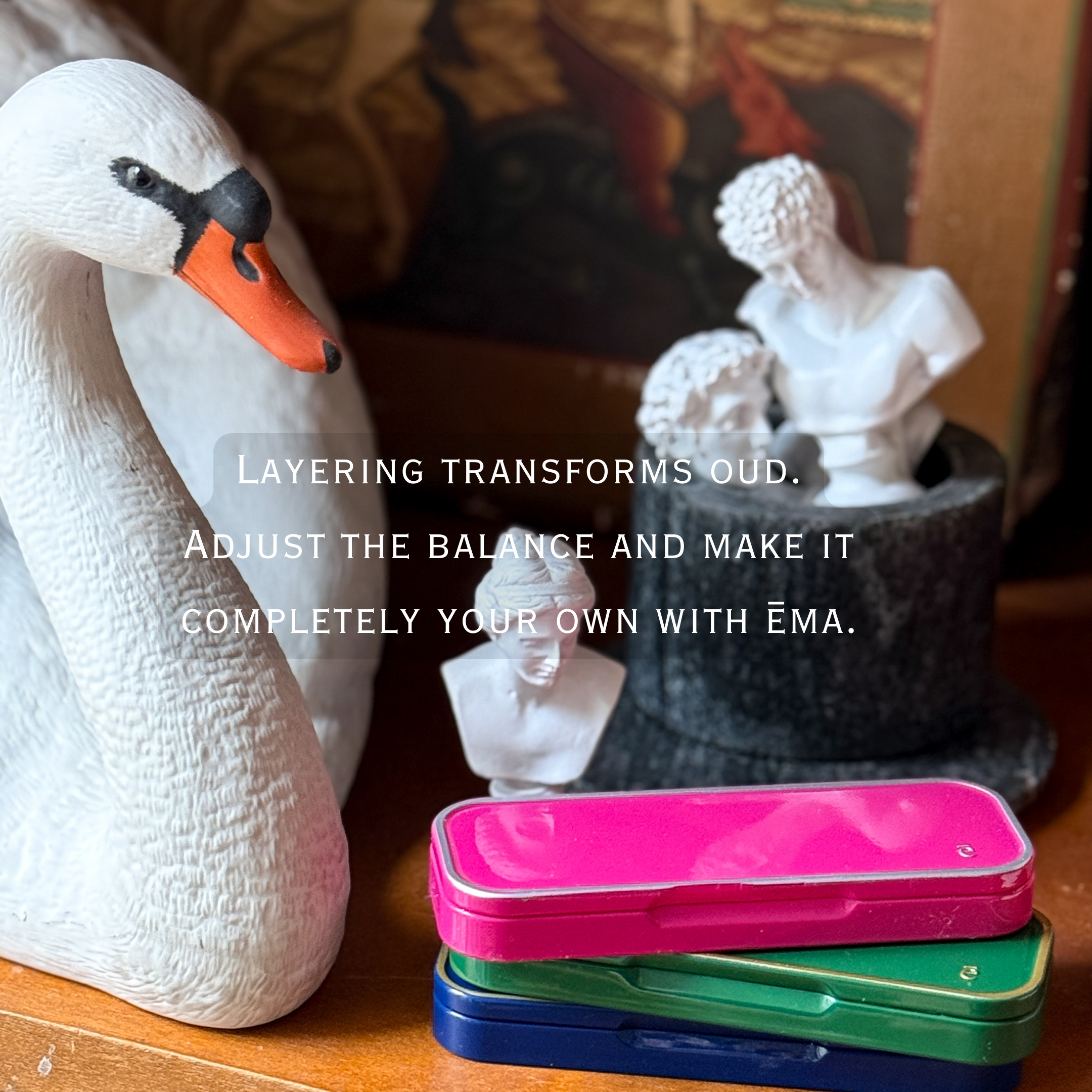 Stack of colorful cases with decorative swan and busts in the background